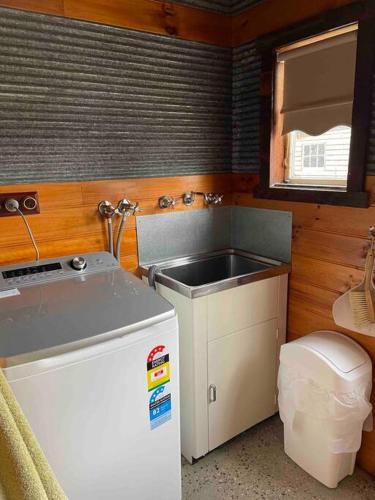 a small kitchen with a sink and a refrigerator at Unique, Rustic Stone Cottage in Canadian