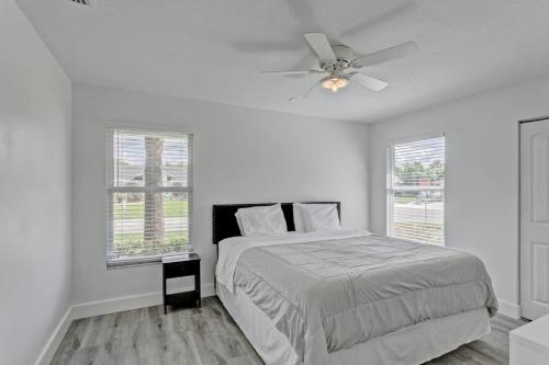a white bedroom with a bed and a ceiling fan at Private Heated Pool Bbq Patio King Beds in Royal Palm Beach