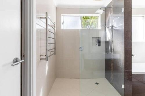 La salle de bains est pourvue d'une douche avec une porte en verre. dans l'établissement NEW! Modern, Cozy 2BR Home Away from Home w/ Wifi, à Perth