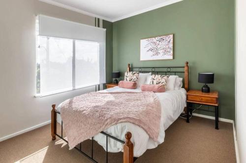 - une chambre avec un lit doté d'oreillers roses et d'une fenêtre dans l'établissement NEW! Modern, Cozy 2BR Home Away from Home w/ Wifi, à Perth