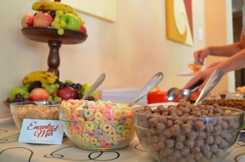 a table topped with bowls of cereal and fruit at Encanto Del Mar in Ostende