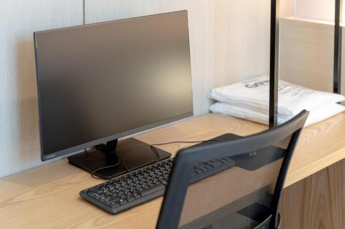 a computer monitor and a keyboard on a desk at Browndot Gangneung Station in Gangneung