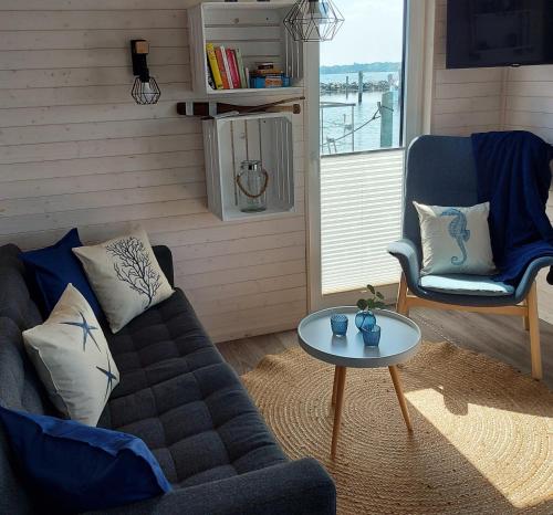 a living room with a couch and a table at Knobis DREAM PLACE in Fehmarnsund