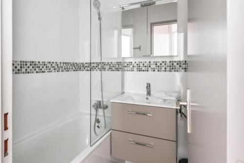 une salle de bain blanche avec un lavabo et une douche dans l'établissement Résidence Les Alpages - maeva Home - 2 Pièces 4 Personnes Sélection MAE-0996, à Morzine