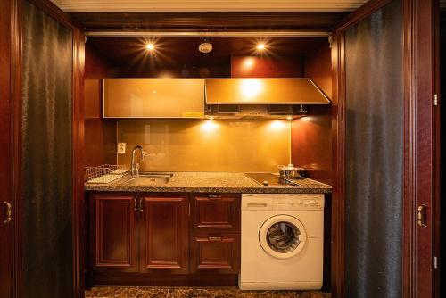 a kitchen with a sink and a washing machine at Yeoksam Artnouveau City Hotel and Residence in Seoul