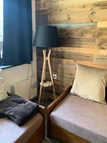 - une chambre avec 2 lits jumeaux et une lampe dans l'établissement Résidence Les Alpages - maeva Home - Studio 5 Personnes - Sélection MAE-0997, à Morzine
