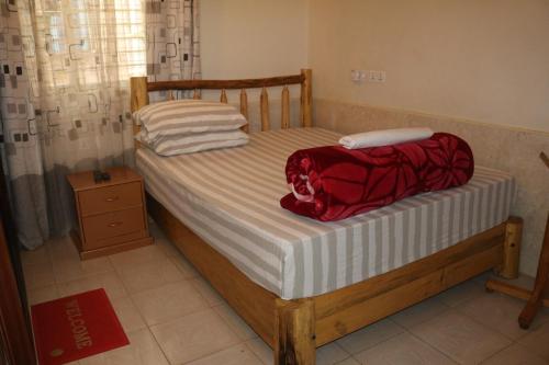 a bed with a red bag on top of it at WEST ORANGE LODGE in Moshi