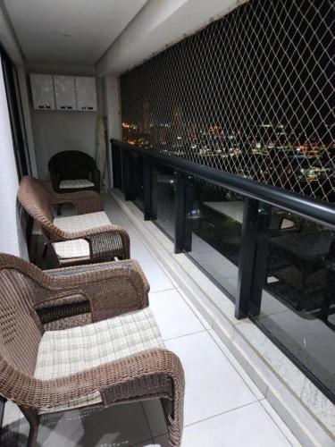2 stoelen op een balkon met uitzicht op de stad bij INOVA FLAT luxo no Condominio Cosmopolitan in Palmas