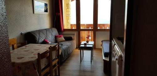 un salon avec un canapé et une table dans l'établissement Résidence Le Sextant - maeva Home - 2 Pièces 4 Personnes Confort MAE-1201, à La Plagne Tarentaise