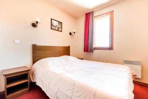 une chambre avec un lit blanc et une fenêtre dans l'établissement Résidence L'Albane - maeva Home - 2 Pièces 5 Personnes Sélection MAE-1255, à Vars