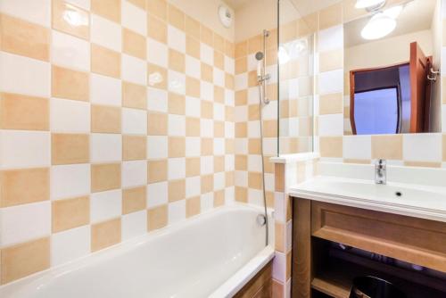 une salle de bain avec une baignoire blanche et un lavabo dans l'établissement Résidence L'Albane - maeva Home - 2 Pièces 5 Personnes Sélection MAE-1255, à Vars