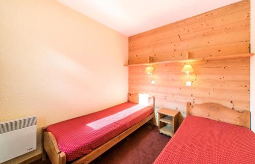 a bedroom with two beds in a room with wooden walls at Quartier Crève Cœur - maeva Home - 2 Pièces 5 Personnes Confort 74 in Valmorel