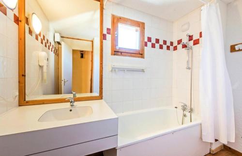 a bathroom with a sink and a tub and a mirror at Quartier Crève Cœur - maeva Home - 2 Pièces 5 Personnes Confort 74 in Valmorel