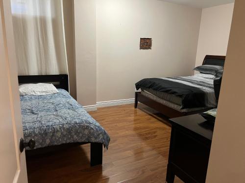 a room with two beds and a table in it at 2 basement basement with parking in Richmond Hill