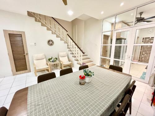 Serene Homestay Semenyih - Endlot House 4BR for 9 pax في سيمينيه: غرفة طعام مع طاولة وكراسي