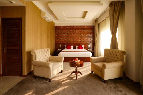 a hotel room with a bed and two chairs at Hotel Dolmaling in Kathmandu