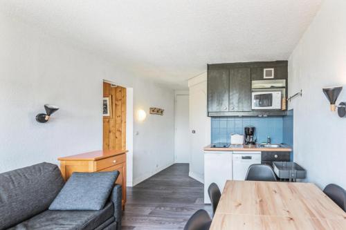 un salon avec un canapé et une table et une cuisine dans l'établissement Résidence Les Portes du Soleil - maeva Home - 2 Pièces 6 Personnes Sélection MAE-1281, à Morzine