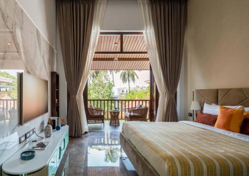 a hotel room with a bed and a balcony at The Bloomers Villa in Vagator