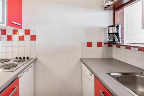 une petite cuisine avec un évier et un comptoir dans l'établissement Résidence Les Alpages - maeva Home - 2 Pièces 4 Personnes Budget MAE-1312, à Morzine