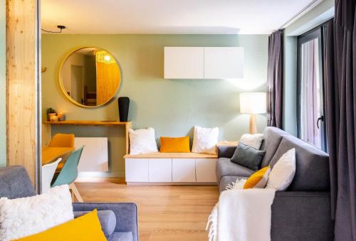 un salon avec un canapé et un miroir dans l'établissement Résidence L'Eyssina - maeva Home - Studio 6 Personnes - Sélection - super Home MAE-1419, à Vars