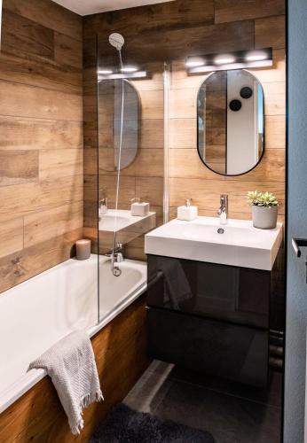 une salle de bain avec un lavabo, une baignoire et un miroir dans l'établissement Résidence L'Eyssina - maeva Home - Studio 6 Personnes - Sélection - super Home MAE-1419, à Vars