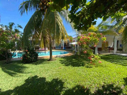 un patio con una piscina y una palmera en Casa de Descanso en Monterrico en Monterrico