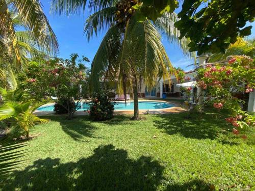 un complejo con piscina y palmeras en Casa de Descanso en Monterrico en Monterrico