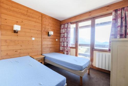 une chambre avec deux lits et une fenêtre dans l'établissement Résidence L'Ours Blanc - maeva Home - 3 Pièces 8 Personnes Prestige MAE-1612, à Huez
