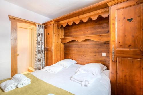 un lit dans une chambre avec un mur en bois dans l'établissement Résidence Les Alpages de Chantel - maeva Home - Appartement 3 Pièces 6 Personnes - Sélection MAE-1538, à Bourg-Saint-Maurice