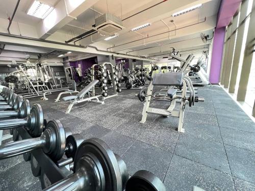 a gym with rows of weights and machines at Qliq Damansara Hotel in Petaling Jaya