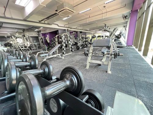 a gym with rows of dumbbells in a row at Qliq Damansara Hotel in Petaling Jaya