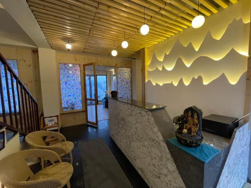 a lobby with a counter and chairs in a room at Yarrows, Narkanda, A boutique stay in Nārkanda