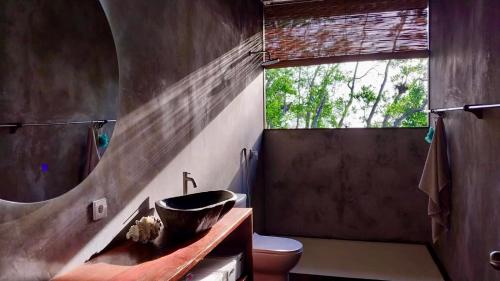 uma casa de banho com um lavatório, um WC e uma janela. em Villa Luzo em Saonek