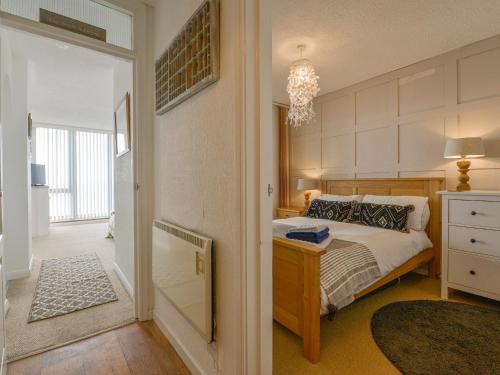 a bedroom with a bed and a door to a hallway at Red Peg in Kingsand