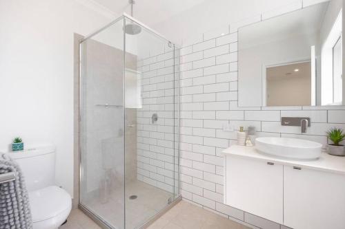 e bagno con doccia, servizi igienici e lavandino. di “Brand New Home” Central Charm at Hervey Bay a Urraween