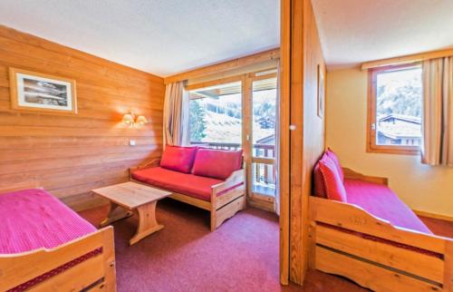 une chambre avec deux lits et une chaise et une fenêtre dans l'établissement Quartier Crève Cœur - maeva Home - Studio 4 Personnes Confort MAE-1767, à Valmorel