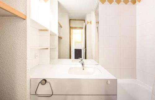 une salle de bain blanche avec un lavabo et un miroir dans l'établissement Quartier Crève Cœur - maeva Home - Studio 4 Personnes Sélection MAE-1773, à Valmorel