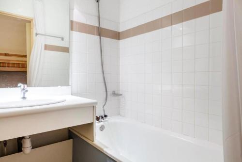 La salle de bains est pourvue d'un lavabo, d'une baignoire et d'une douche. dans l'établissement Résidence L'Eyssina - maeva Home - Studio 5 Personnes Budget MAE-1940, à Vars