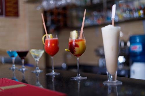 four cocktails in wine glasses on a bar at Tiffany Diamond Hotels - Mtwara in Mtwara