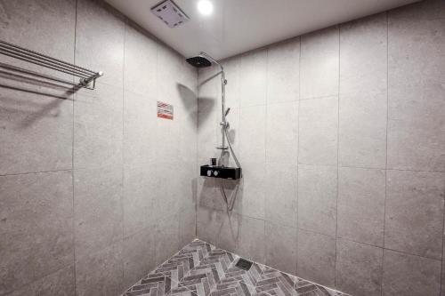 Łazienka z prysznicem i podłogą wyłożoną kafelkami w obiekcie Haute Hotel w Pusanie