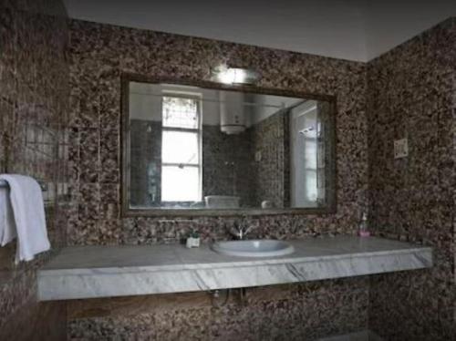 a bathroom with a sink and a mirror at Kastle Guest House in New Delhi