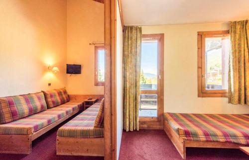 un salon avec un canapé et une fenêtre dans l'établissement Quartier Crève Cœur - maeva Home - Studio 4 Personnes Confort MAE-3073, à Valmorel