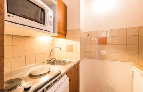 une petite cuisine avec un évier et un micro-ondes dans l'établissement Quartier Crève Cœur - maeva Home - Studio 4 Personnes Confort MAE-3073, à Valmorel