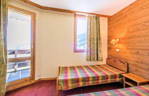 1 dormitorio con cama y ventana en Les Résidences de Valmorel - maeva Home - 2 Pièces 5 Personnes Confort 74, en Valmorel