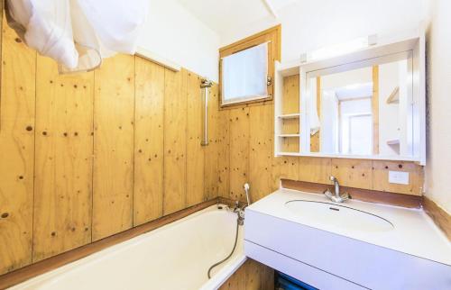 une salle de bain avec un lavabo, une baignoire et un miroir dans l'établissement Quartier La Forêt - maeva Home - 2 Pièces 5 Personnes Confort MAE-3074, à Valmorel