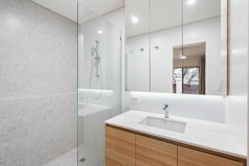 a white bathroom with a sink and a shower at Bay Village Resort Dunsborough in Dunsborough