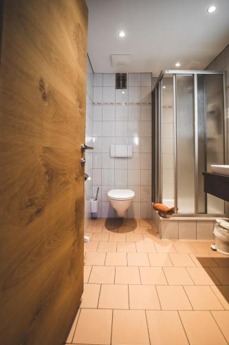 a bathroom with a toilet and a glass shower at Pension Sonnenheim in Schönberg im Stubaital