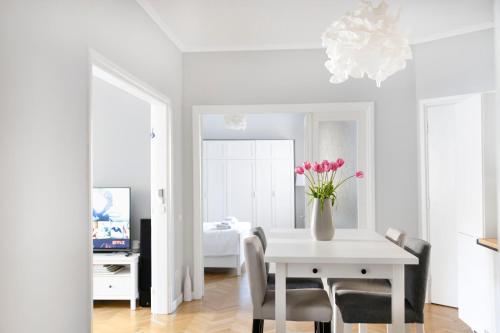 a white room with a table with a vase of flowers at Your Deluxe Home in Bucharest center in Bucharest