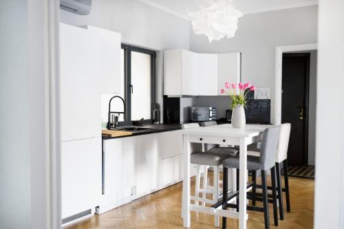 a kitchen with white cabinets and a table with chairs at Your Deluxe Home in Bucharest center in Bucharest