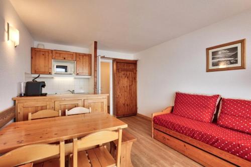 un salon avec un canapé rouge et une table dans l'établissement Résidences quartier Charmettoger - maeva Home - 2 Pièces 5 Personnes Sélection MAE-3657, à Arc 1800